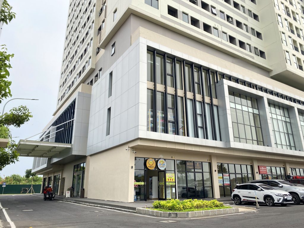 Gedung perkantoran modern bertingkat dengan area ruko di lantai dasar dan area parkir di depan gedung