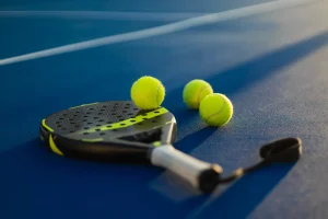 raket dan bola padel di lapangan biru untuk event padel