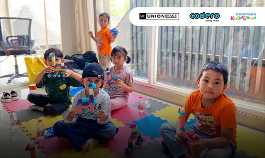 Tips Terbaik Sewa Ruang Kantor di Jakarta Anak sedang menunjukkan hasil susunan balok kreatif dalam kegiatan Creative Space Solo Radio di UnionSPACE Solo Radio bersama Codero dan Innovera.